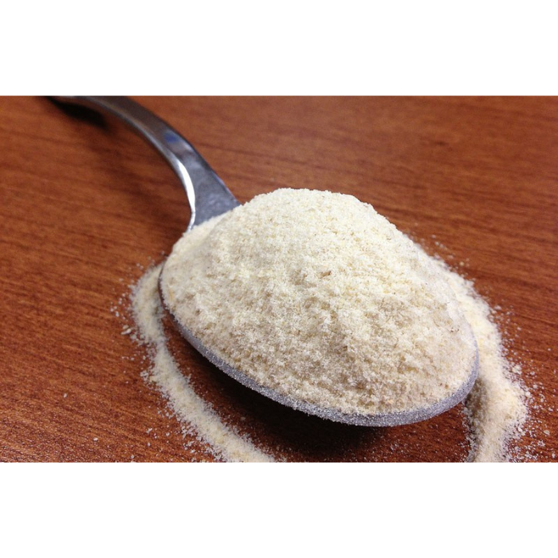 A Spoonful Of Organic Kamut Flour Laying On A Wooden Table