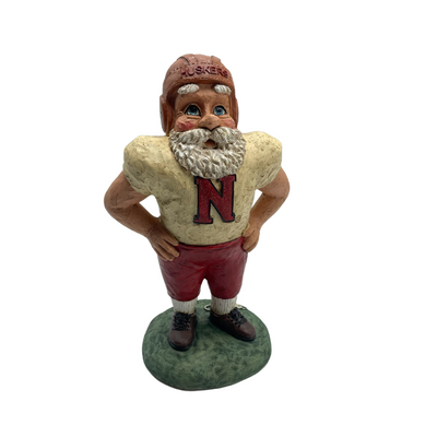 Santa stutue in retro Nebraska Cornhusker football uniform, standing with hands on hips shown on a white background