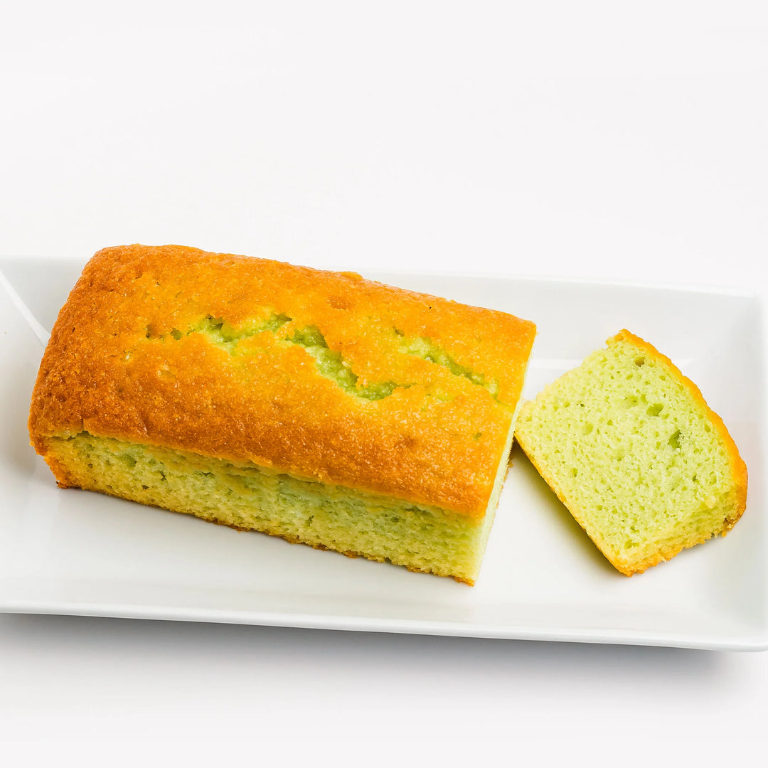 Loaf of bread with a slice cut out on a white plate