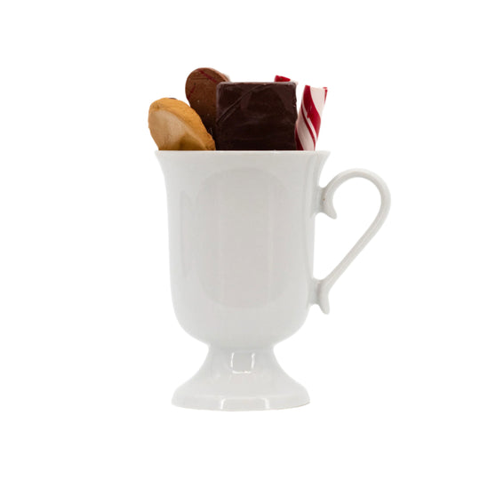White ceramic mug filled with cookies on a white background
