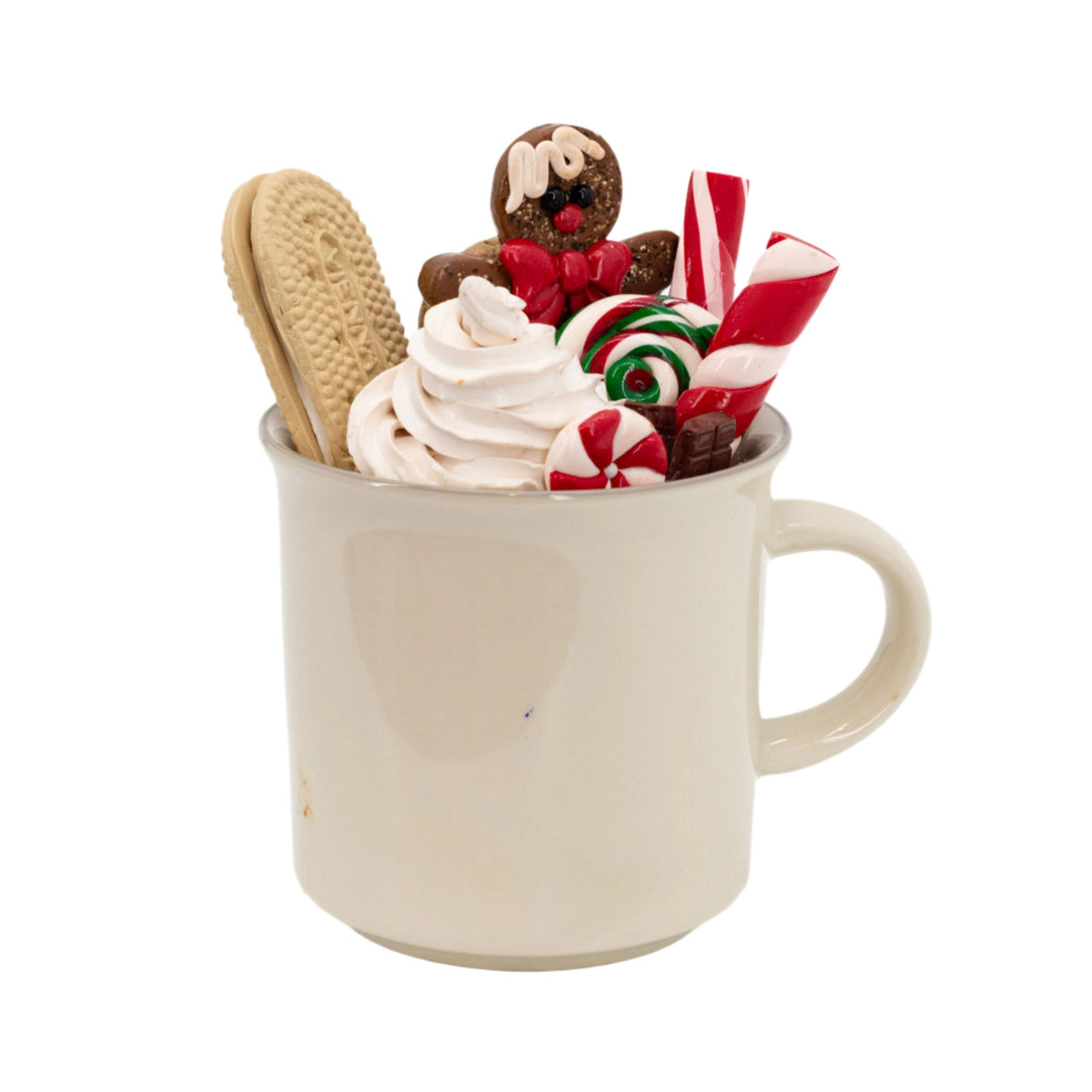 Mug with whipped cream, cookies, and candy canes on a white background