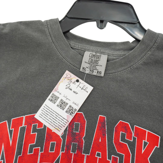 Gray t-shirt with red 'NEBRASKA' text and a tag on a white background