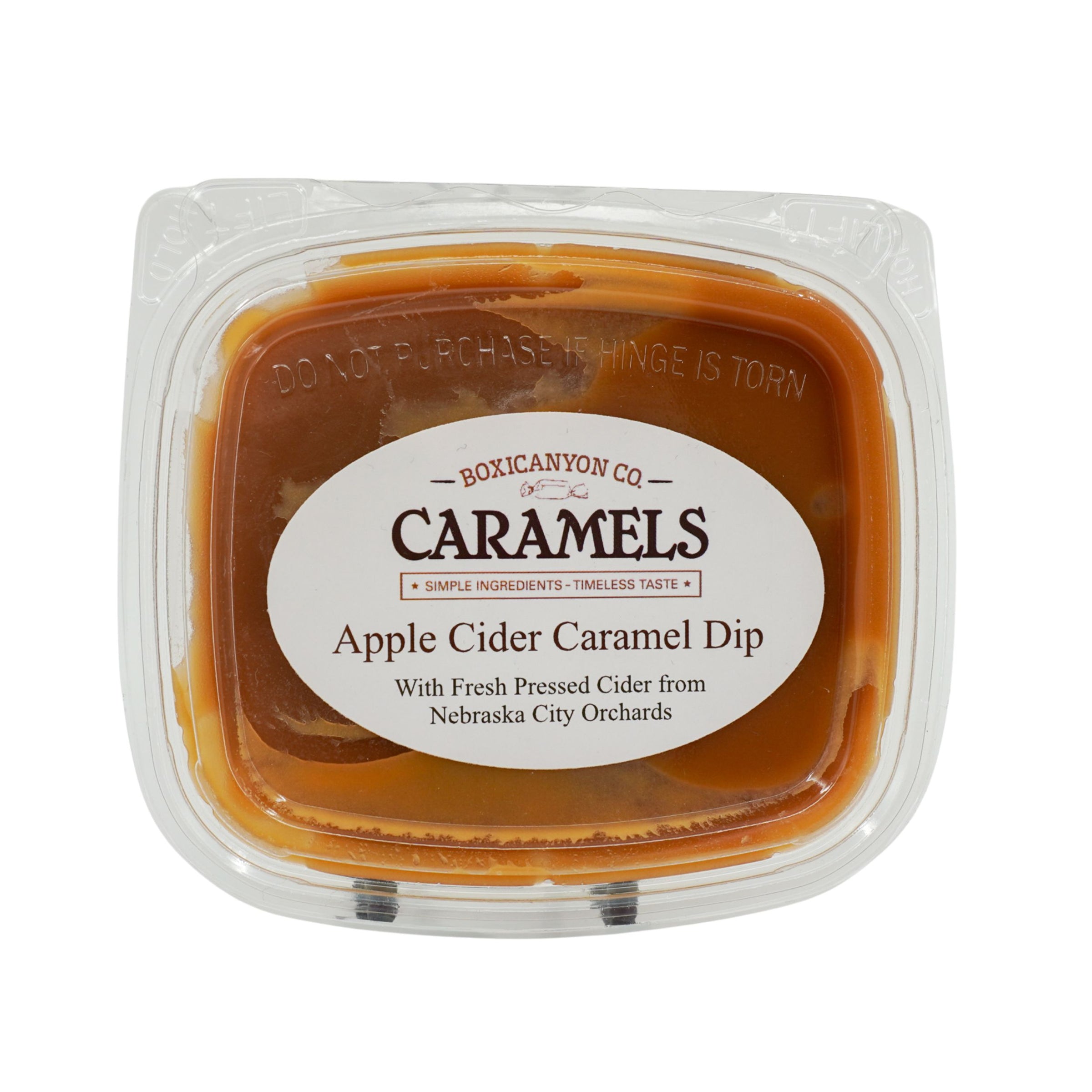 Apple cider caramel dip in a clear container with a label on a white background