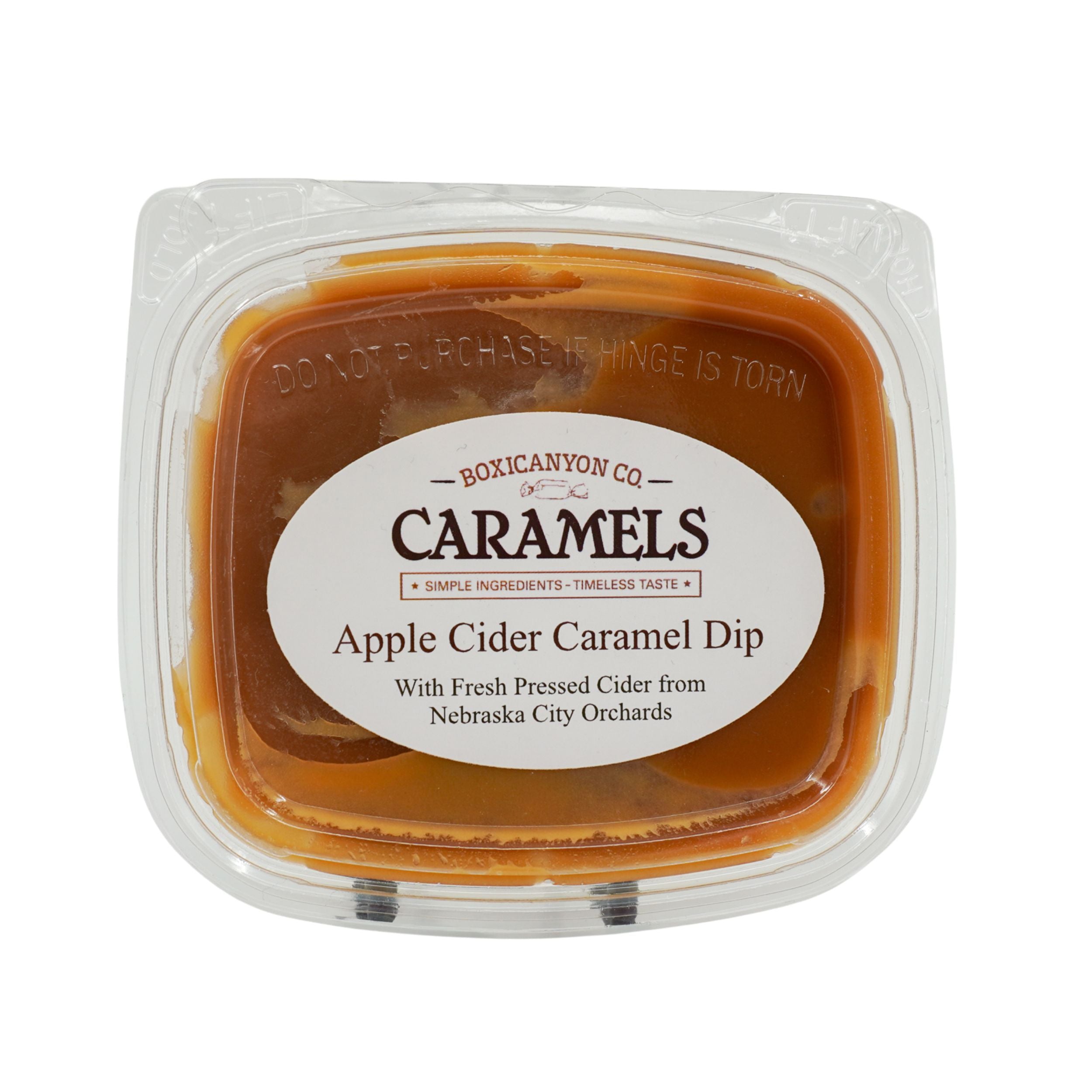 Apple cider caramel dip in a clear container with a label on a white background