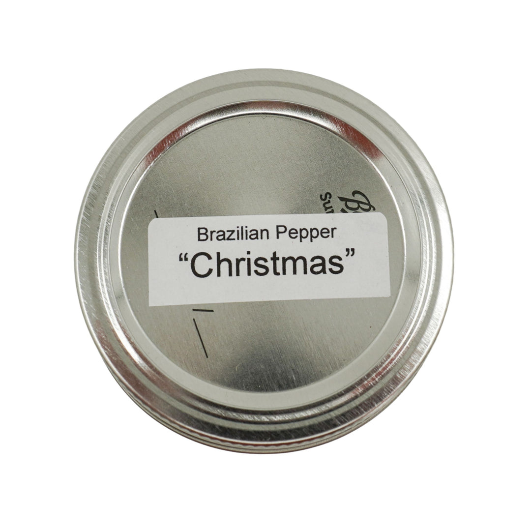 Metallic container lid with 'Brazilian Pepper Christmas' label on a white background