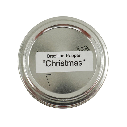 Metallic container lid with 'Brazilian Pepper Christmas' label on a white background