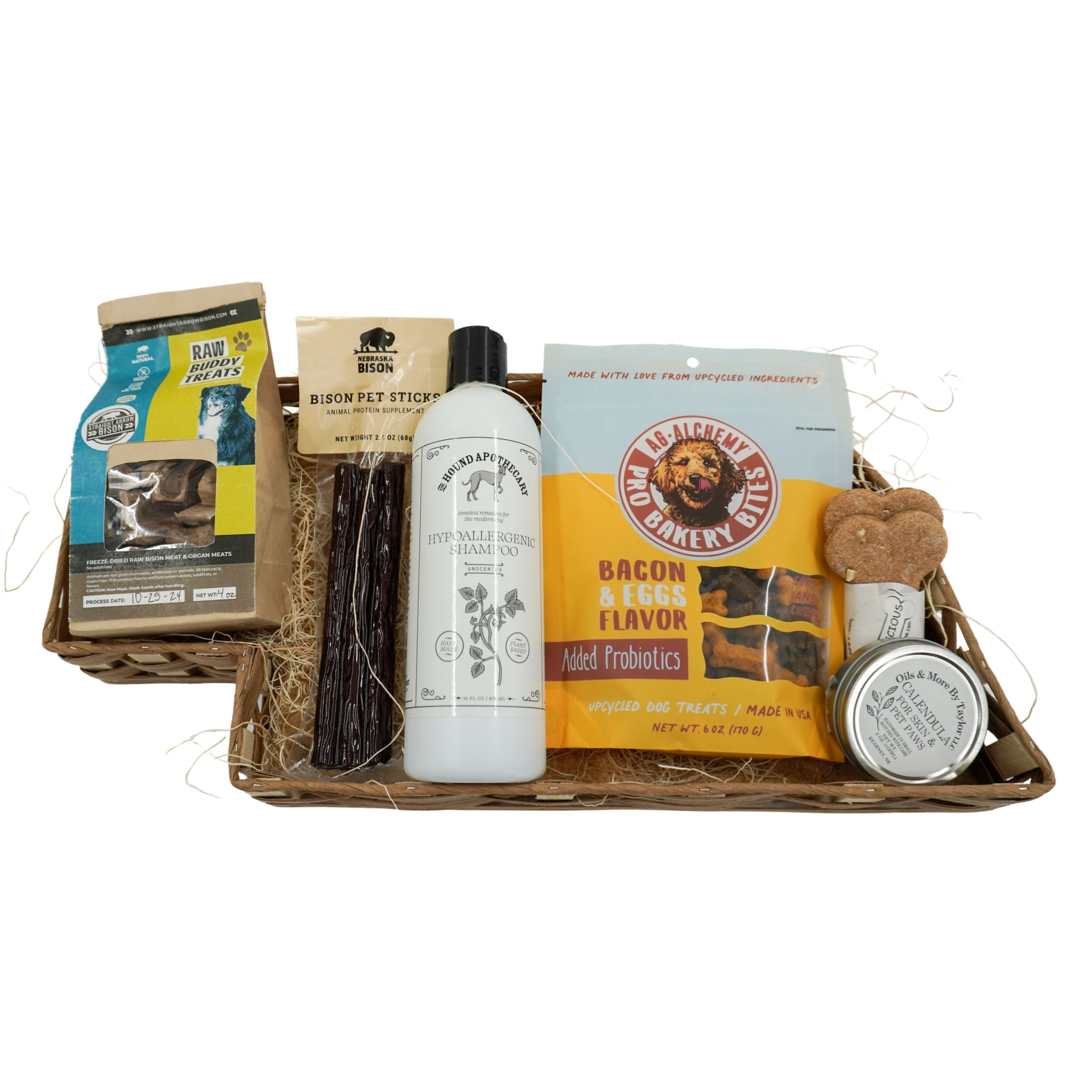 Basket of pet care products including treats, a bottle, and a jar on a white background