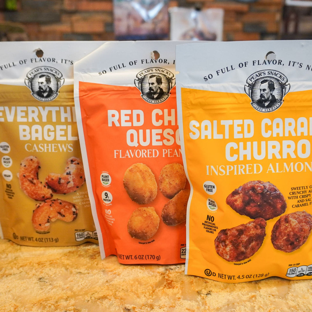 Three bags of snack products on a wooden surface with a blurred background