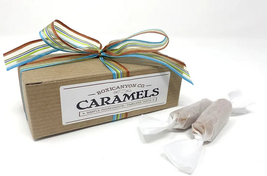 A gift box of caramels with a colorful bow.