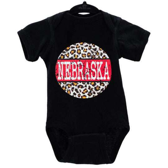 A black infant onesie with a cheetah print design and the word 'NEBRASKA' written across the center in red and white letters.