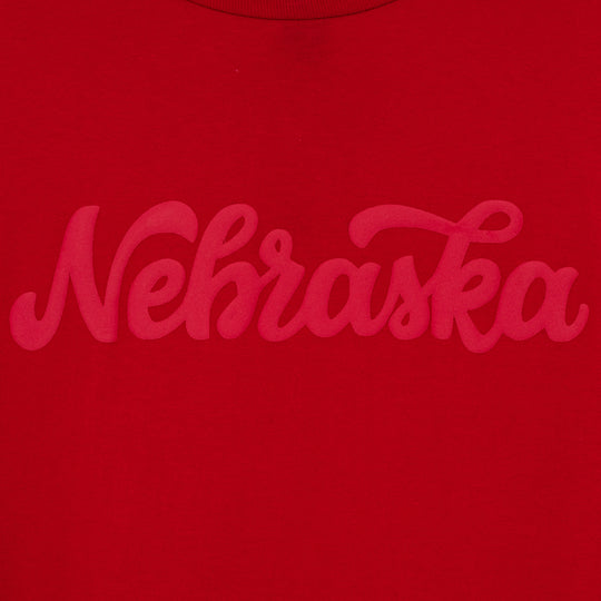 close up view of red cursive font on front of a red long-sleeve t-shirt.