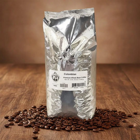 Silver coffee bag labeled 'Colombian' with coffee beans on a wooden surface