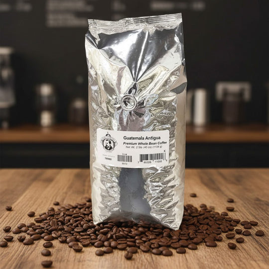 Coffee bag labeled 'Guatemala Antigua' with coffee beans on a wooden surface