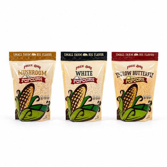 Three packages of Free Day Popcorn with different flavors on a white background