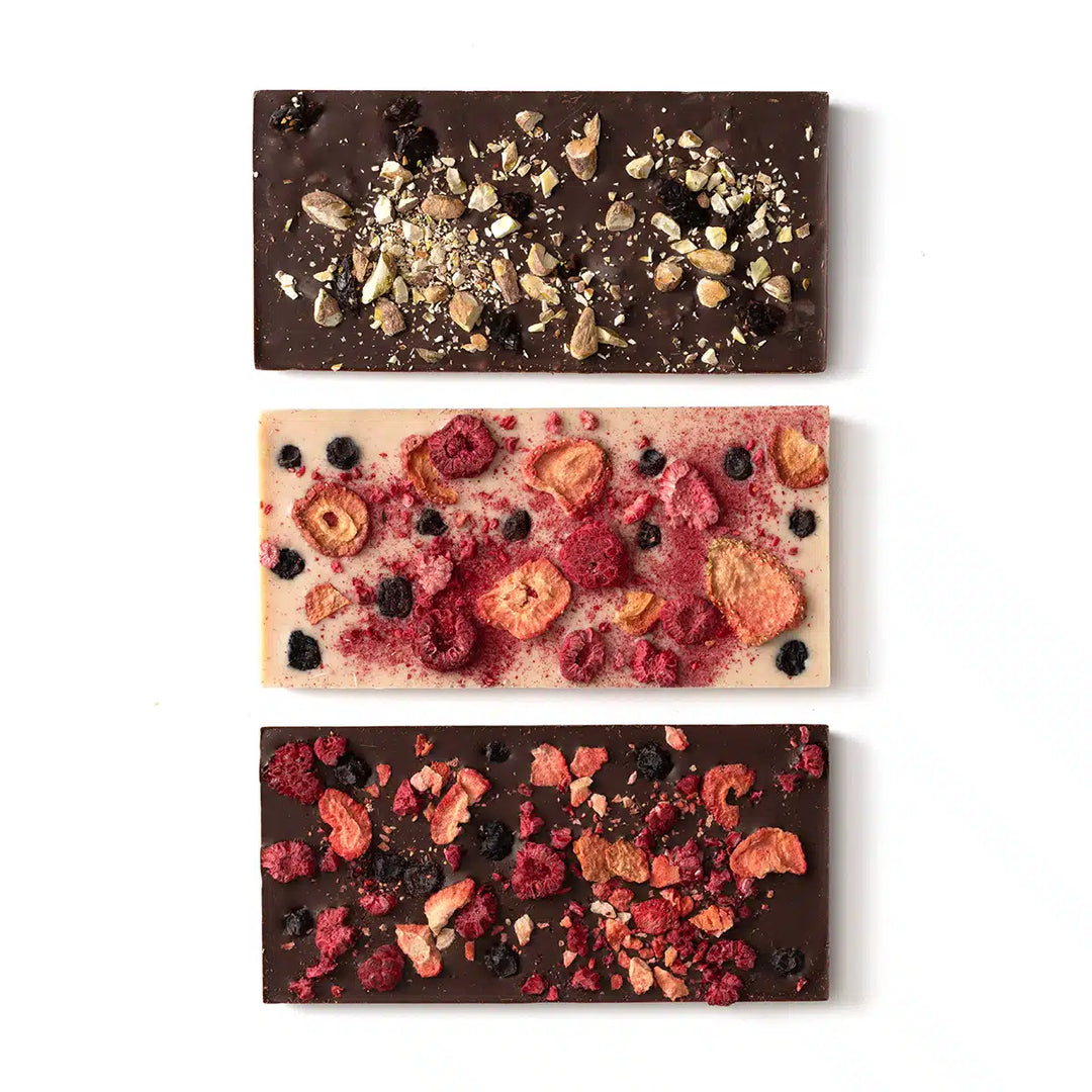 Three different chocolate bars with various toppings on a white background