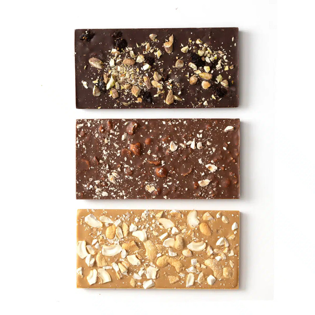 Three different chocolate bars with various toppings on a white background