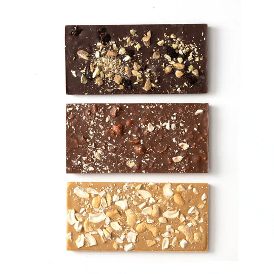 Three different chocolate bars with various toppings on a white background