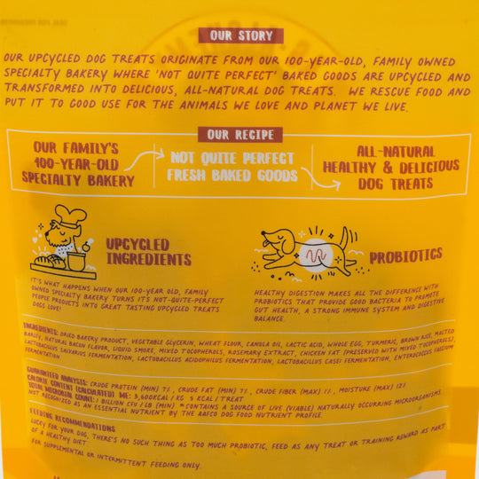 Dog treat packaging with text about the brand's story, recipe, and ingredients on a yellow background.