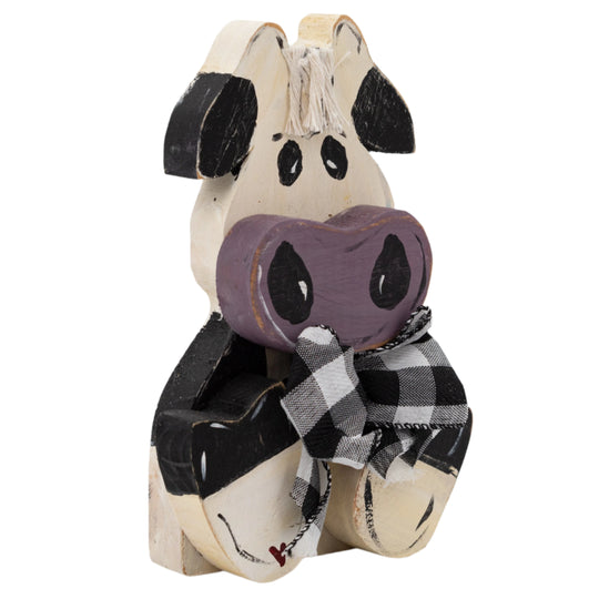 Wooden cow figurine with a purple heart and plaid ribbon on a white background