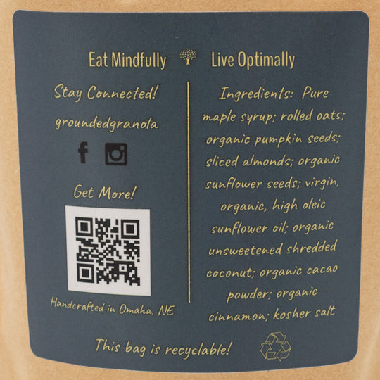 Back of a granola bag with text, QR code, and recycling symbol on a cardboard background