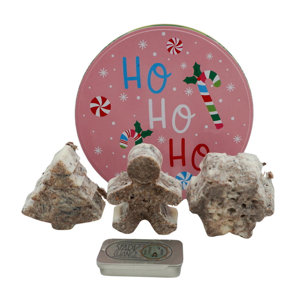 Three fire starters in front of a 'Ho Ho Ho' Christmas tin.