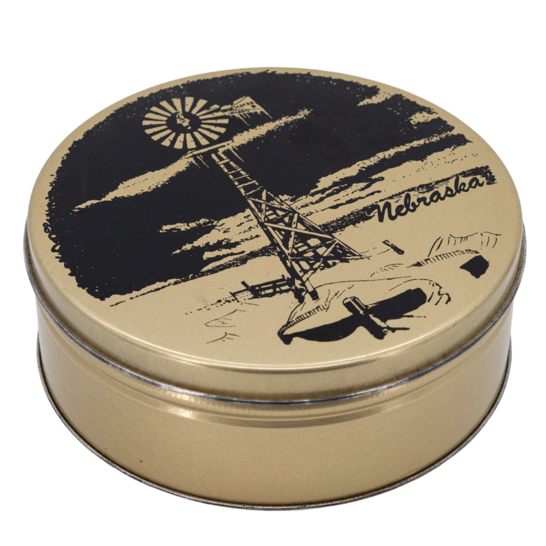 Round metal tin with black windmill illustration on a white background