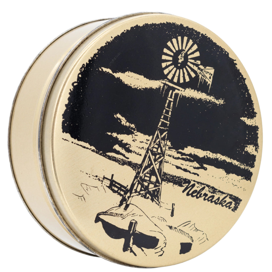 Round container with a black and gold illustration of a windmill and 'Nebraska' text on a white background
