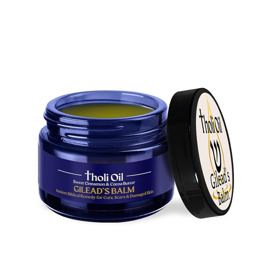 Open jar of Tholi Oil Gilead's Balm with visible balm inside on a white background