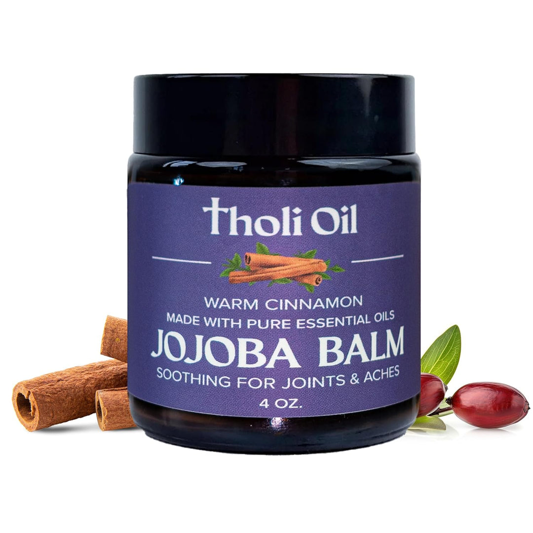 Jojoba balm jar with cinnamon sticks and jojoba beans on a white background