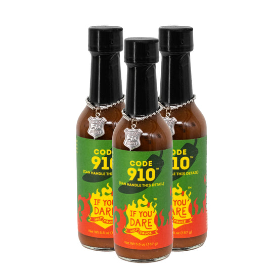 Three bottles of Code 910 hot sauce with colorful labels on a white background