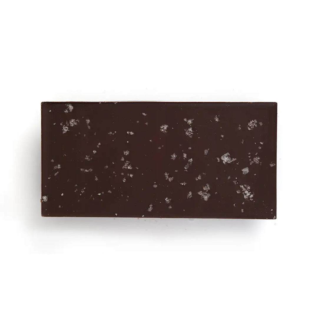 Rectangular dark brown chocolate bar with sea salt on a white background