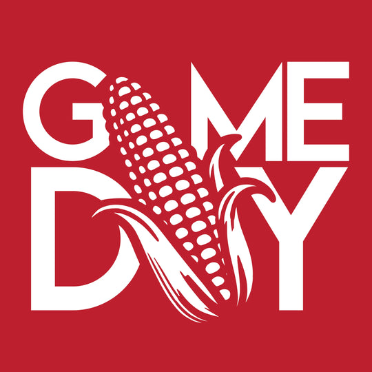 A graphic design featuring the word 'GAMEDAY' in bold white letters with a stylized corn cob illustration crossing the center, set against a solid red background.