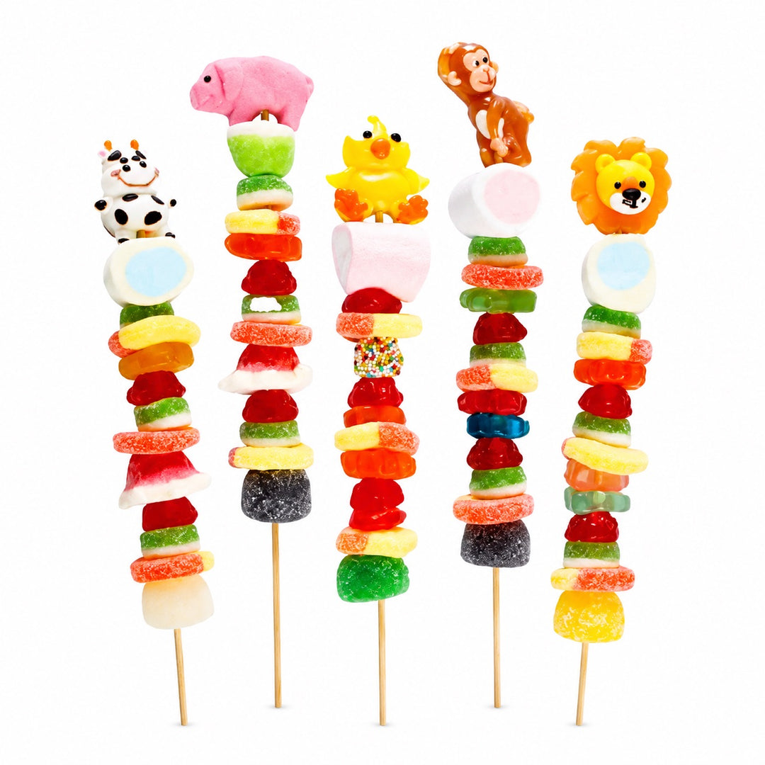 Animal candy kabob collection featuring cow, pig, chicken, monkey, and lion candy toppers with assorted fruit-flavored candies on wooden skewers, isolated on a white background.