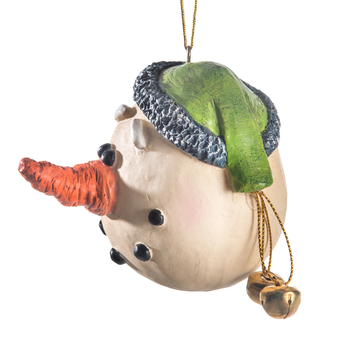 A snowman ornament with a textured cream-colored body, a green and gray knit hat, an orange carrot nose, and small gold bells hanging from a gold hanging string, shown on a plain white background.