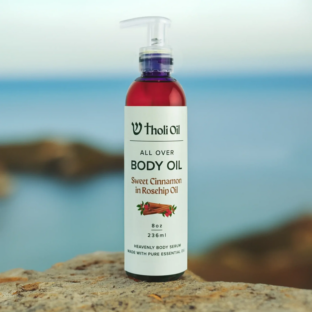 Bottle of Tholi Oil body oil on a rock with a blurred natural background
