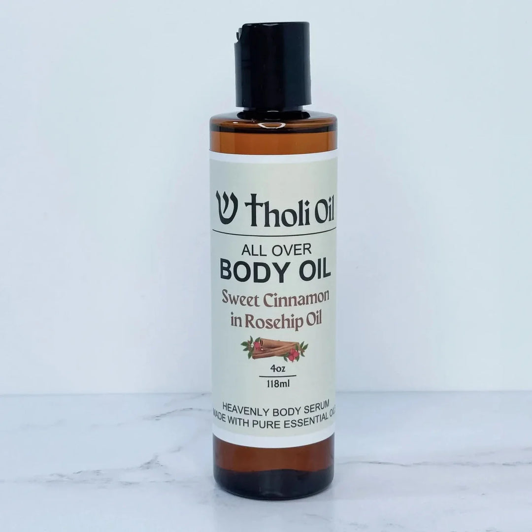 Bottle of Tholi Oil All Over Body Oil on a white marble surface
