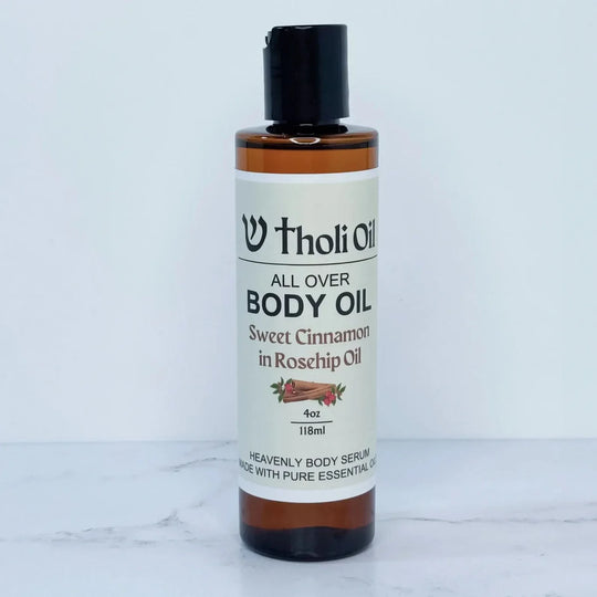 Bottle of Tholi Oil All Over Body Oil on a white marble surface
