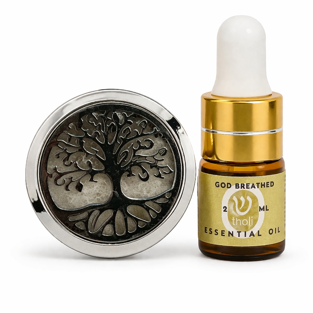 Essential oil dropper bottle with gold cap and label, next to a metal container with tree design on a white background.