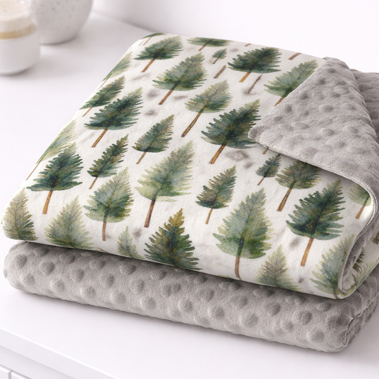 Folded blanket with tree pattern on a white surface
