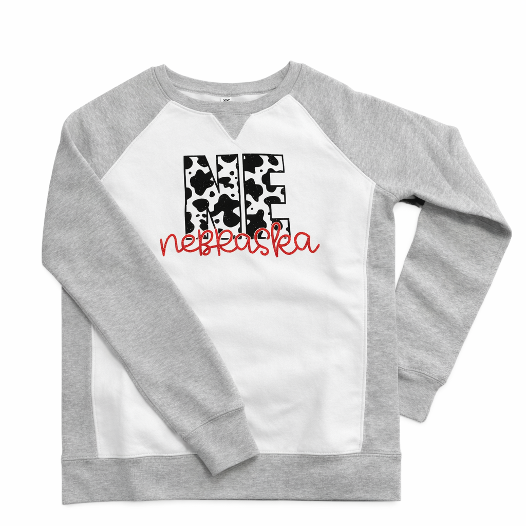 Gray and white sweatshirt with cow print and text design on a white background