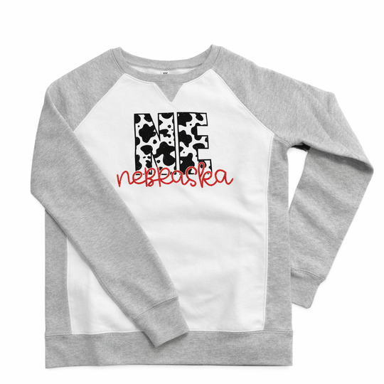Gray and white sweatshirt with cow print and text design on a white background