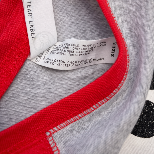 Close-up of a label on a garment with red and gray fabric.