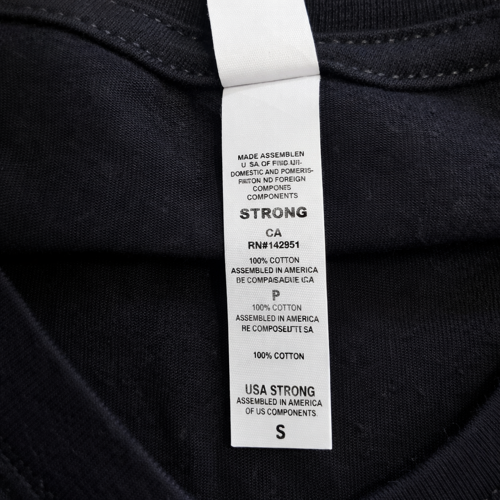 Close-up of a label on a black garment with text details.