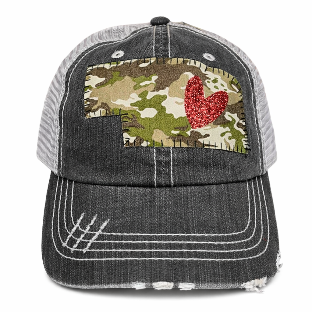 Black distressed trucker cap with camouflage patch and red heart on a white background
