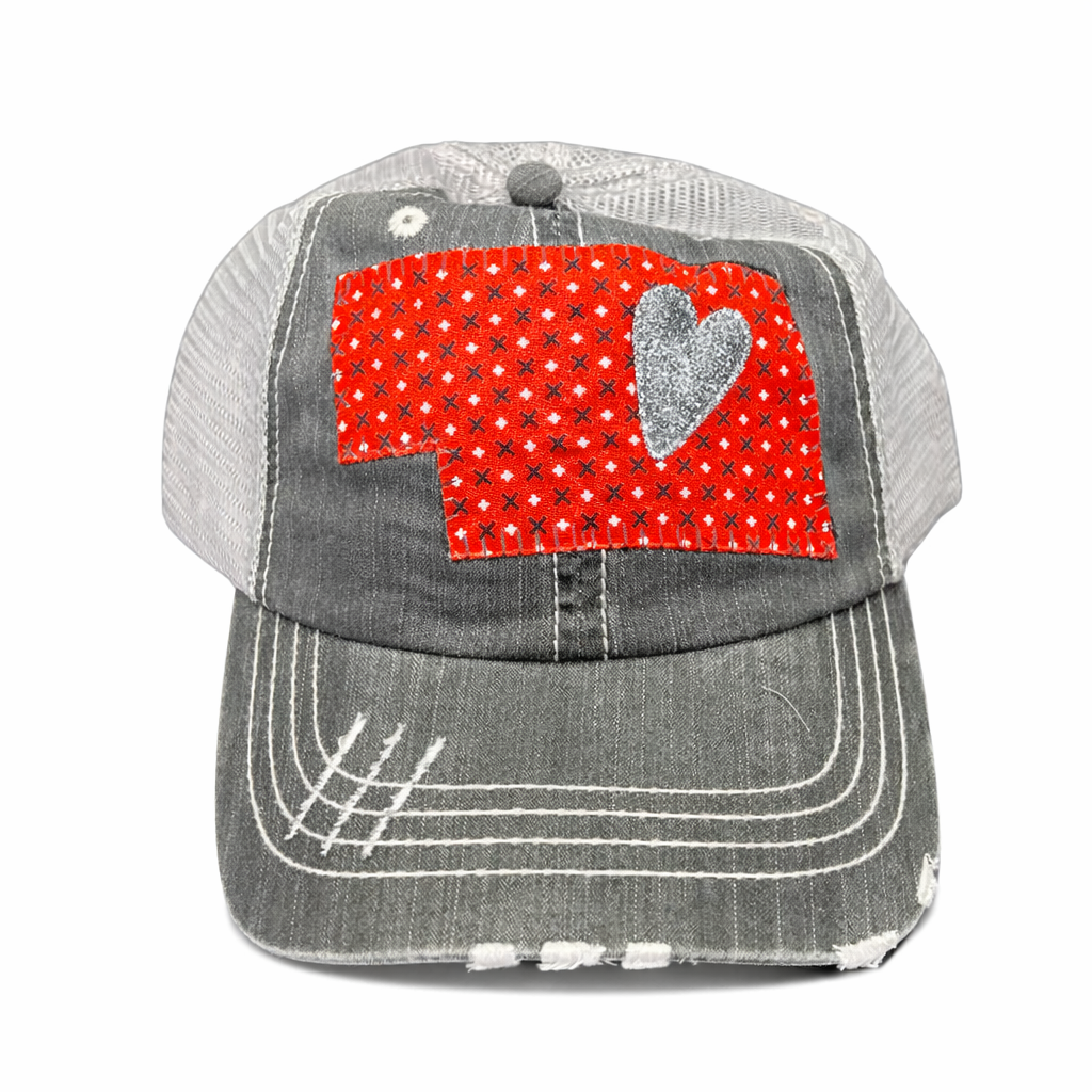 Gray cap with a red and white patterned heart design on a white background