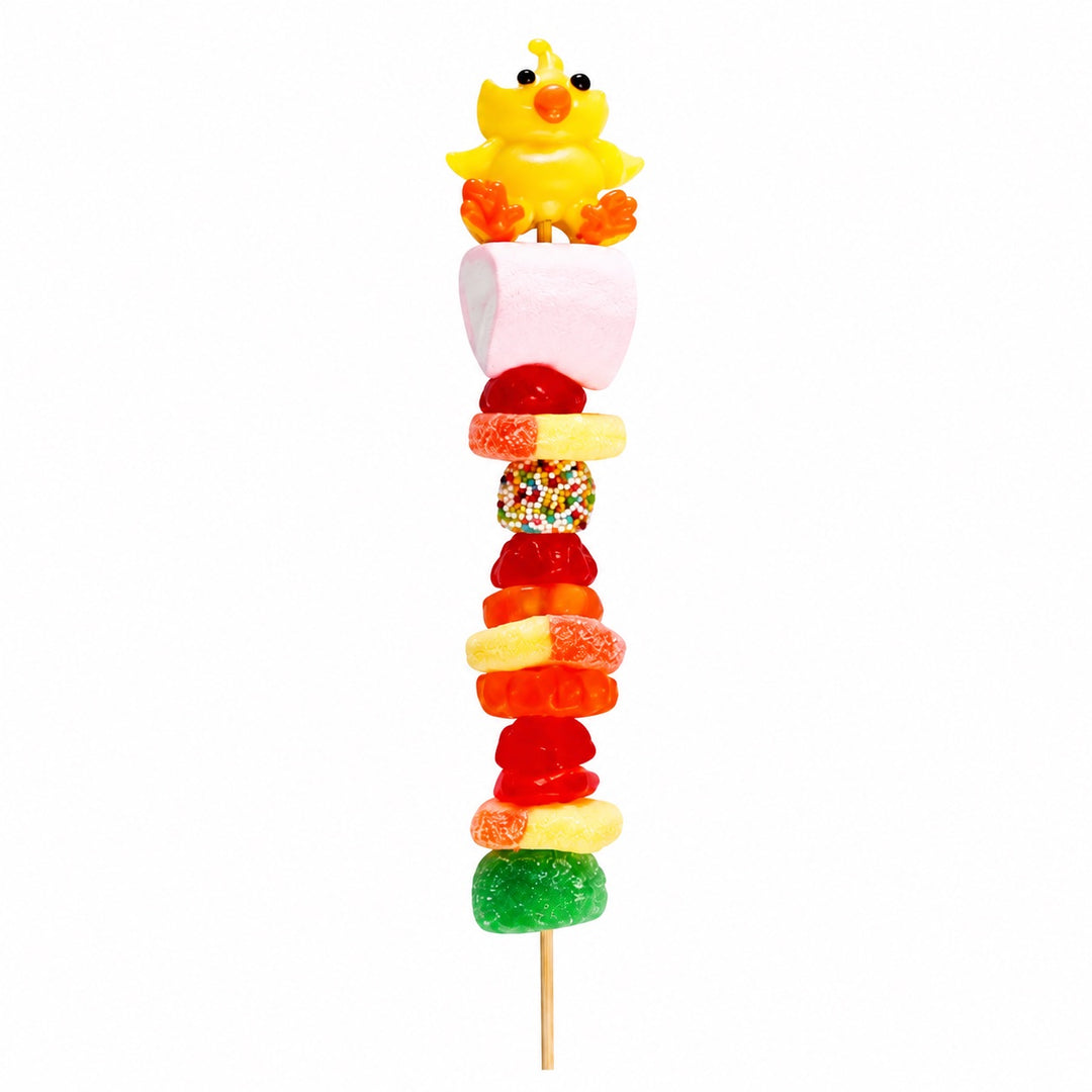 Chicken candy kabob featuring a yellow chick candy topper and assorted fruit-flavored candies on a wooden skewer, isolated on a white background.