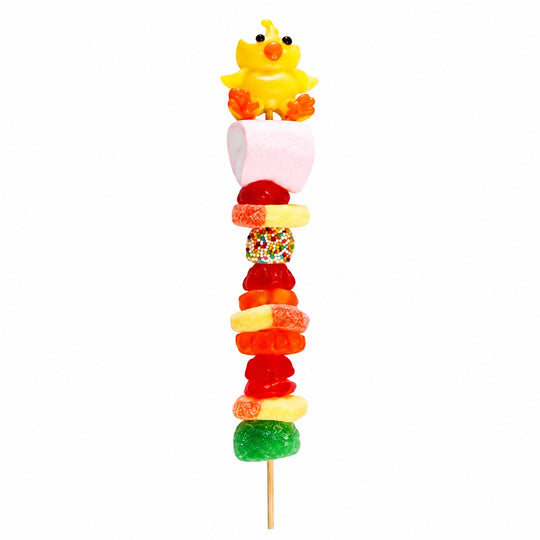 Chicken candy kabob featuring a yellow chick candy topper and assorted fruit-flavored candies on a wooden skewer, isolated on a white background.