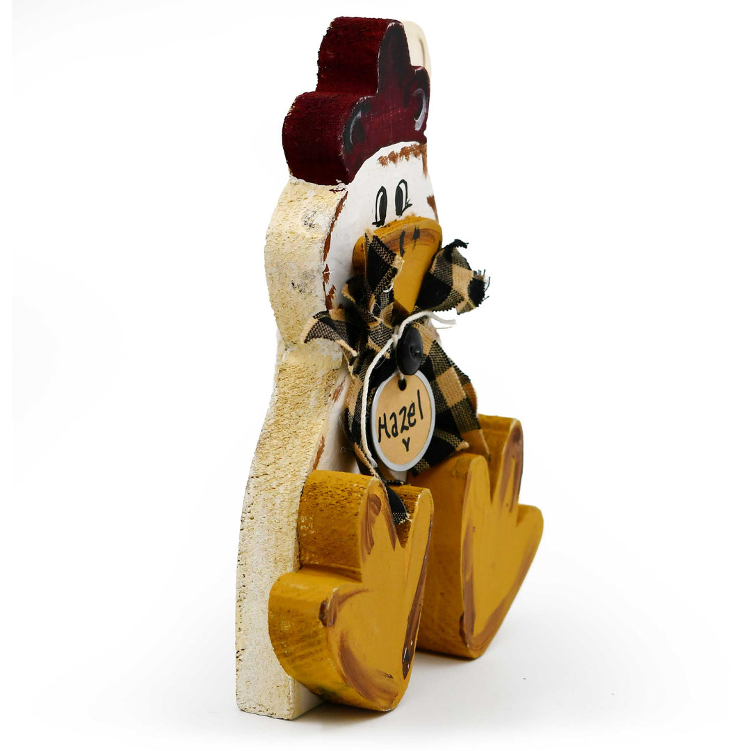 Decorative wooden chicken figure with a checkered bow tie and tag on a white background