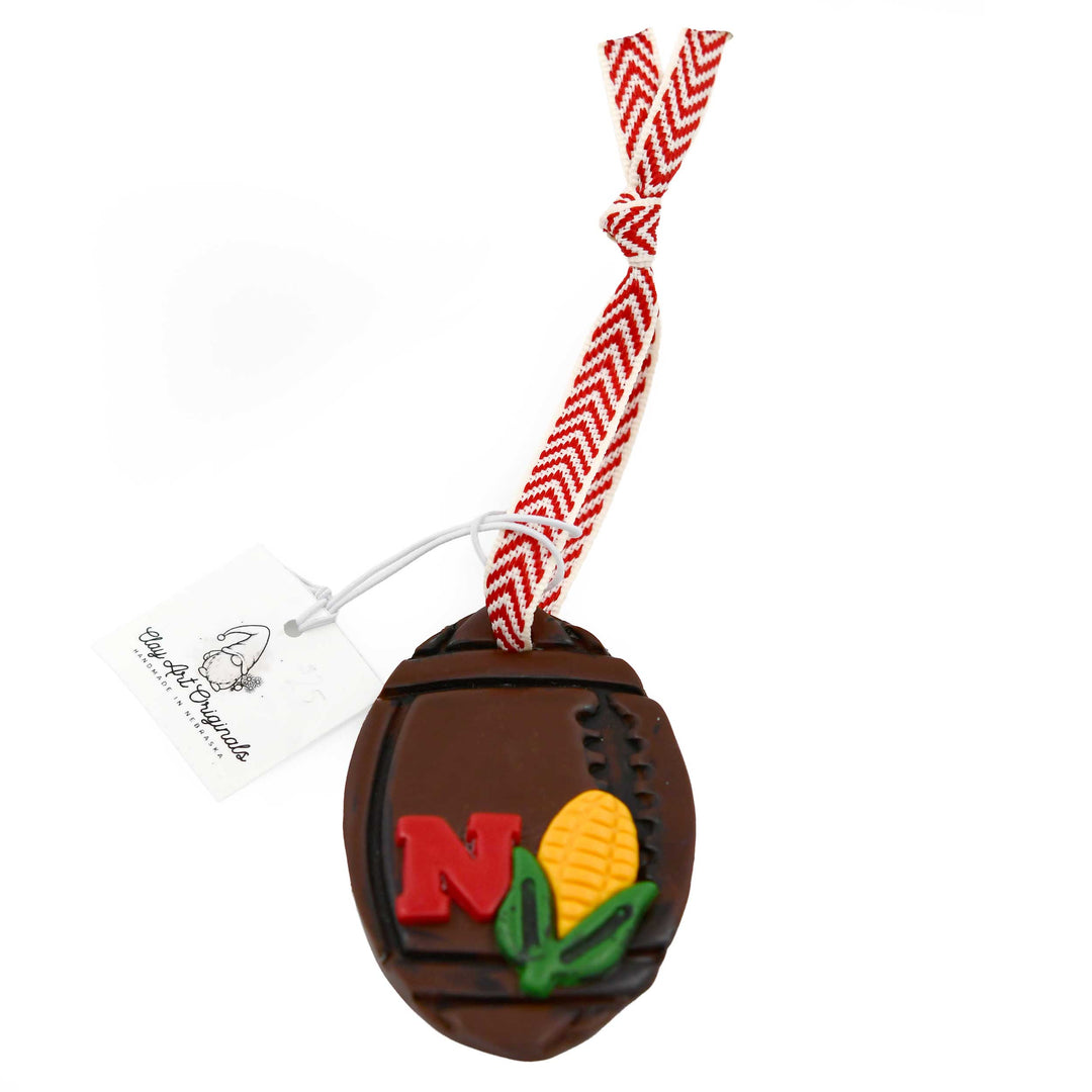 Decorative football-shaped ornament with 'N' and corn design on a white background