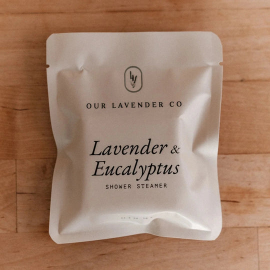 Shower steamer packaging with 'Our Lavender Co' branding on a wooden surface